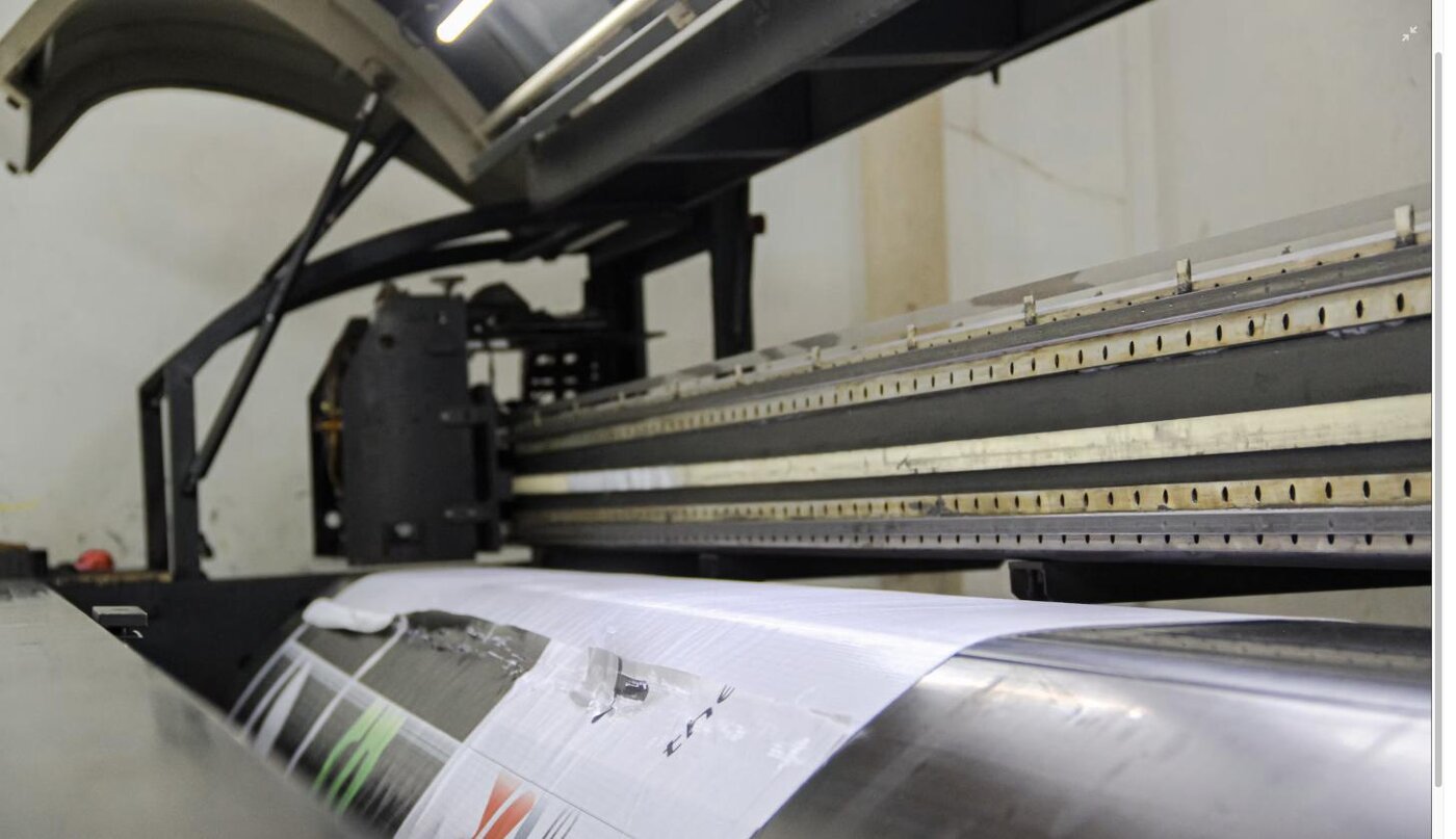 Rows of framed canvas prints being inspected on a production line