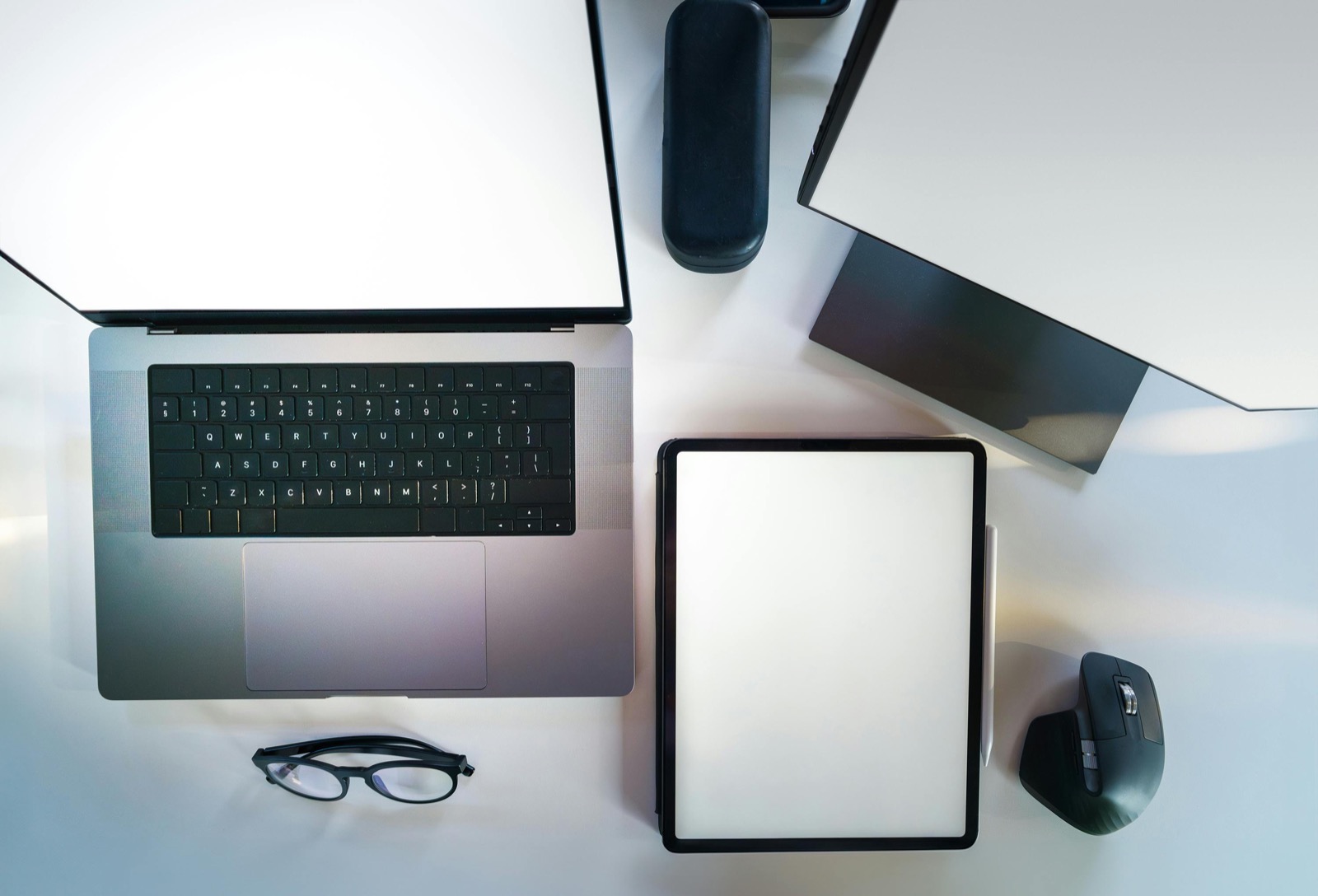 Overhead view of a modern desk with laptop and tablet